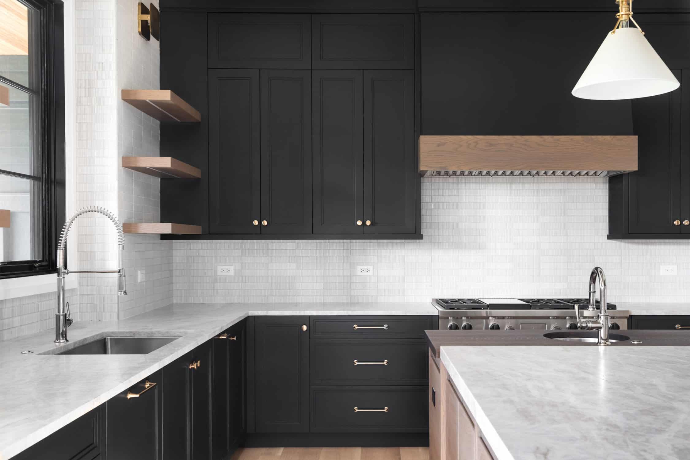 A black kitchen with stainless steel appliances.